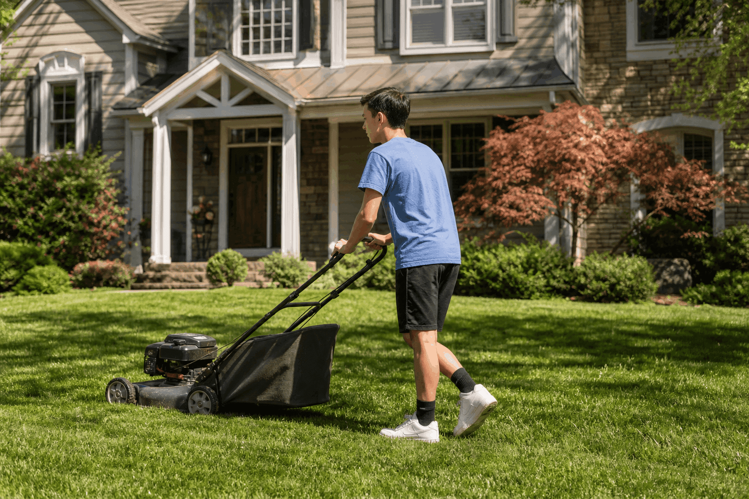 Young neighbor mowing a lawn